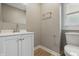 Bright bathroom with a white vanity, modern fixtures, and a toilet near a window at 2720 S Taft Ave, Indianapolis, IN 46241