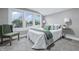 Sunlit bedroom with a comfortable bed, a chair, and a large window with green trees at 2720 S Taft Ave, Indianapolis, IN 46241