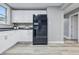 Modern kitchen with white cabinets, black refrigerator, and light-colored floors at 2720 S Taft Ave, Indianapolis, IN 46241