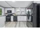 Well-lit kitchen with wood-look flooring and black appliances at 2720 S Taft Ave, Indianapolis, IN 46241
