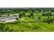 Aerial view showcasing a golf course with a pond, and surrounding green landscape at 289 Sandbrook Dr, Noblesville, IN 46062