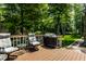 Outdoor deck with seating area, grill, and a tranquil view of a wooded backyard at 289 Sandbrook Dr, Noblesville, IN 46062