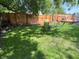 Shady back yard featuring a fire pit, lawn, and wood fence with deck beyond at 302 Penn St, Westfield, IN 46074