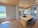 Open kitchen with stainless steel refrigerator, large island, wood floors, and wooden ceiling at 302 Penn St, Westfield, IN 46074