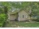 Exterior backyard view showcasing the home's siding, surrounded by lush greenery and trees at 3028 Hovey St, Indianapolis, IN 46218