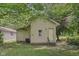 Backyard view showing the house exterior, a green lawn, and leafy trees providing shade at 3028 Hovey St, Indianapolis, IN 46218