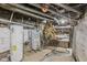 Unfinished basement featuring water heaters, exposed pipes, and potential for various uses at 3028 Hovey St, Indianapolis, IN 46218