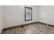 A clean bedroom featuring neutral-colored walls and sleek floors, with a window offering natural light at 3028 Hovey St, Indianapolis, IN 46218