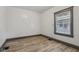 This bedroom features light-colored wood floors and a window with neutral trim and blinds at 3028 Hovey St, Indianapolis, IN 46218
