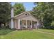Charming home exterior with a brick walkway and front porch and lush green lawn at 3028 Hovey St, Indianapolis, IN 46218