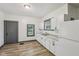 Efficient kitchen featuring white cabinets, modern countertops, and a bright window at 3028 Hovey St, Indianapolis, IN 46218