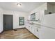 Bright kitchen featuring white cabinets, granite countertops, and new laminate flooring at 3028 Hovey St, Indianapolis, IN 46218