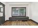 Bright living room featuring light wood-look flooring and a large window seat at 3028 Hovey St, Indianapolis, IN 46218