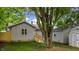 Backyard with wooden ramp to back door, large shade tree and wood fence in the background at 311 S 6Th Ave, Beech Grove, IN 46107