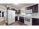 Well-equipped kitchen featuring white appliances, dark cabinets, and ample counter space at 311 S 6Th Ave, Beech Grove, IN 46107
