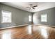 Spacious bedroom featuring hardwood floors, a ceiling fan, and three large windows at 33 N Webster Ave, Indianapolis, IN 46219