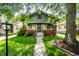 Charming home with green siding, brick accents, front garden and covered porch at 33 N Webster Ave, Indianapolis, IN 46219