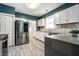 Modern kitchen with stainless steel appliances, white cabinets, and tile backsplash at 33 N Webster Ave, Indianapolis, IN 46219