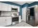 Kitchen with stainless steel appliances, white cabinetry, and stylish tile floors at 33 N Webster Ave, Indianapolis, IN 46219
