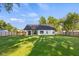 Expansive backyard featuring lush green lawn, wood fencing, and a charming home exterior at 3365 Riverside Dr, Columbus, IN 47203