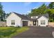 Attractive exterior shows modern farmhouse design, a black asphalt driveway, and well-manicured lawn at 3365 Riverside Dr, Columbus, IN 47203