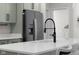 Charming kitchen island with stainless steel fridge and modern matte black faucet with light countertops at 3365 Riverside Dr, Columbus, IN 47203