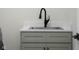 Stylish laundry area features a stainless steel sink with black faucet, light green cabinets, and black hardware at 3365 Riverside Dr, Columbus, IN 47203