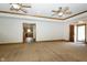 Bright, open living room with tray ceilings, neutral carpet, and kitchen view at 3717 Bellmore Dr, Brownsburg, IN 46112