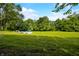 A large, grassy backyard features an above-ground pool with a deck and furniture, surrounded by mature trees at 379 N Marion St, Morgantown, IN 46160