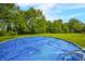 A covered above-ground pool sits in a spacious, tree-lined backyard under a blue sky with light clouds at 379 N Marion St, Morgantown, IN 46160
