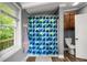 A full bathroom with wood-look flooring, modern fixtures and a bright blue shower curtain at 379 N Marion St, Morgantown, IN 46160