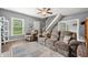 A cozy living room with hardwood floors has an oversized couch, chair, staircase, and neutral color scheme at 379 N Marion St, Morgantown, IN 46160