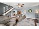 A comfy living room with wood floors has an oversized couch and chair, stairs, and access to other rooms at 379 N Marion St, Morgantown, IN 46160