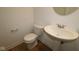 Stylish half bathroom featuring a pedestal sink, modern toilet, and sleek wood floors at 3917 Highcrest Rd, Indianapolis, IN 46239