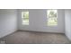 A bright bedroom with plush carpet and two windows overlooking the outdoor landscape at 3917 Highcrest Rd, Indianapolis, IN 46239