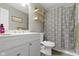 Bright bathroom featuring a new vanity, toilet, shower with decorative curtain and wood look floors at 422 W Broadway St, Greenwood, IN 46142