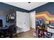 Bedroom featuring bright blue walls with colorfully painted stripes with a closet and light wood floors at 422 W Broadway St, Greenwood, IN 46142