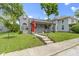 Attractive gray home with a red front door, landscaped yard, and classic design at 422 W Broadway St, Greenwood, IN 46142