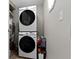 A clean laundry room with a stacked washer and dryer, light switch and a small storage table at 422 W Broadway St, Greenwood, IN 46142