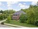 Aerial view of a well-maintained brick house on a manicured lot with mature trees at 4529 Panthera Leo Dr, Carmel, IN 46074