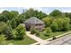 Aerial view of a brick house with well-manicured lawn, driveway and mature trees at 4529 Panthera Leo Dr, Carmel, IN 46074