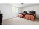 Bright bedroom with two twin beds, dark wood headboards, and bedside tables under a window at 4529 Panthera Leo Dr, Carmel, IN 46074