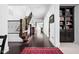 Elegant hallway with hardwood floors, a staircase with wrought iron railing, and custom built-in shelving at 4529 Panthera Leo Dr, Carmel, IN 46074