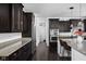 Contemporary kitchen featuring dark wood cabinetry, stainless steel appliances, granite countertops and a center island at 4529 Panthera Leo Dr, Carmel, IN 46074