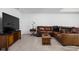 Basement living room features a leather sectional sofa and a flat screen tv atop wooden cabinet at 4529 Panthera Leo Dr, Carmel, IN 46074