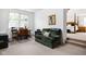 Cozy sitting room with a green sofa, desk area and view into the bedroom at 4529 Panthera Leo Dr, Carmel, IN 46074