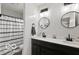 Stylish bathroom featuring double sinks, modern fixtures, and a shower-tub combination with a patterned curtain at 4605 Clairmont Dr, Columbus, IN 47203