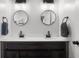 Beautiful bathroom with a double sink vanity featuring white counters, round mirrors, and dark wood cabinets at 4605 Clairmont Dr, Columbus, IN 47203