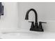 Close up view of a modern black faucet set against a bright white countertop and sink basin at 4605 Clairmont Dr, Columbus, IN 47203