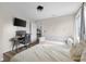 Bright bedroom featuring a beige bed, white couch, hardwood floors, study desk, and a television at 4605 Clairmont Dr, Columbus, IN 47203